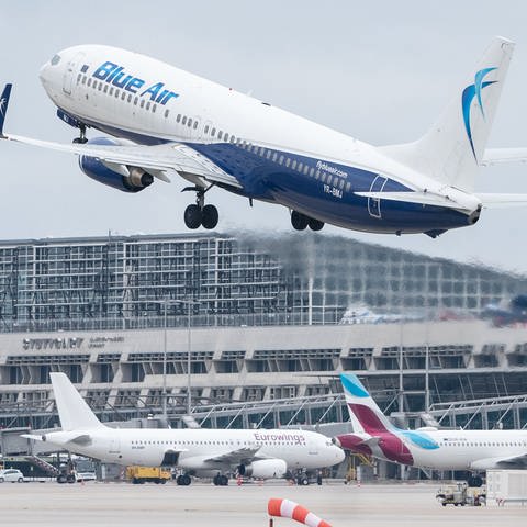 Ein Flugzeug der Fluggesellschaft Blue Air startet am Flughafen Stuttgart, dahinter ist Terminal 1 des Flughafens zu sehen.